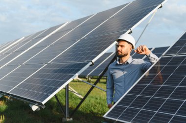 Sakallı mühendis, yenilenebilir enerji santralindeki güneş panellerini denetleyerek temiz enerji üretimi ve bakımını sağlıyor.