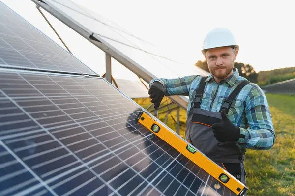 Adam yenilenebilir enerji üretimi için güneş panelleri kuruyor, ruhsal seviyeye uygun hizayı sağlıyor ve onaylama gösteriyor