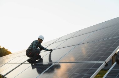 İşçi temiz enerji üretimi için güneş panelleri kuruyor. Sürdürülebilirlik ve çevre korumasının teşvik edilmesi