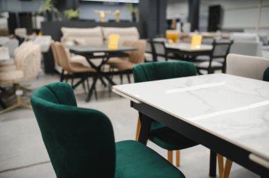 Modern dining table with elegant green velvet chairs showing comfortable home interior decoration in a furniture showroom