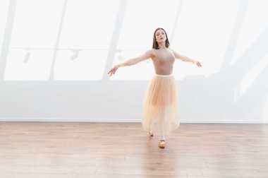 Genç balerin, güneşli bir stüdyoda zarif hareketlerini çalışıyor. Bale dansçılarının kendini adamışlığını ve tutkusunu sergiliyor.