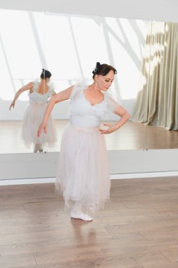 Bir dans stüdyosunda bale adımları atan zarif bir balerin, sanatına kendini adamış ve zarafet sergiliyor.