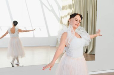 Bir dans stüdyosunda bale figürleri yapan seçkin bir balerin, sanatına kendini adamış ve zarafet sergiliyor.