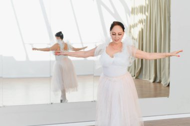 Yaşlı balerin bir dans stüdyosunda bale hareketleri yapıyor, ihtiyarlıkta dans etmeye kendini adamış ve zarafet gösteriyor.