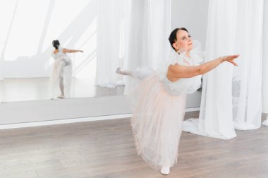 Yaşlı balerin bir dans stüdyosunda bale çalışıyor, yaşlılıkta dans için zarafet ve tutku sergiliyor.