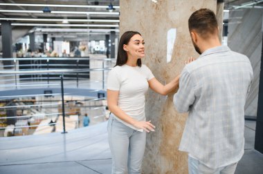 Yeni evleri için mermer ya da fayans seçen genç bir çift modern bir geliştirme mağazasında tasarım fikirlerini tartışıyor.