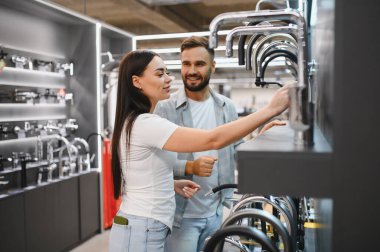 Hırdavatçıda yeni mutfak ya da banyo musluğu seçen genç çift, evlerini yenilemeyi planlıyor.