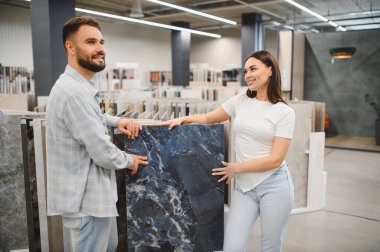 Geniş mavi mermer desenli seramik seramik döşemeye bakan genç bir çift.