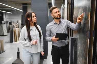 Modern bir hırdavatçı galerisinde seramik seramik seramik seramik seramik malzemeler seçen bir bayan müşteriye