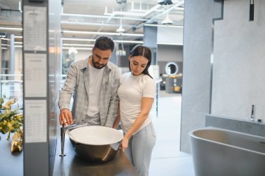 Çift yeni bir lavabo ve modern musluk seçiyor, evlerini yenilemeyi ve geliştirmeyi planlıyor.