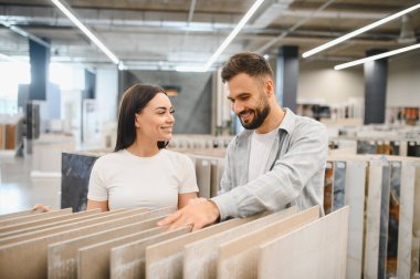 Mutlu çift bir hırdavatçıda yeni döşeme döşemeleri seçiyor. Bir sonraki ev geliştirme ve yenileme projelerini planlıyorlar.