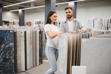 Ev tadilatı için yeni döşeme taşları seçen çift. Evlerinin iç kısımları için karar veriyorlar.