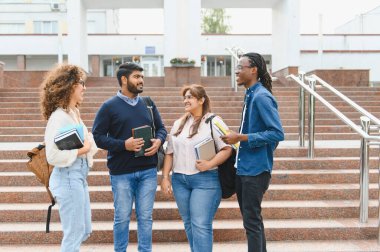 Group of diverse university students connecting and socializing on campus stairs, holding books and backpacks