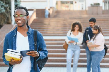 Young diverse students walking and studying on a university campus, showing education, learning, and friendship outdoors