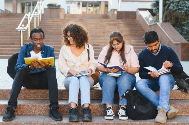 University students sitting on steps, enjoying collaborative learning and preparing for exams on campus