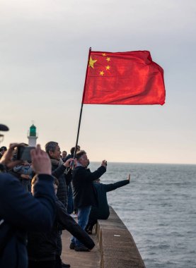 LES SABLES D'OLONNE, FRANCE - FEBRUARY 18, 2025: Supporters with the Chinese flag for the arrival of skipper Jingkun Xu for Vendee Globe 2024 on February 18,2025. in Les Sables d'Olonne, France. clipart