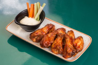 Barbekü tavuk kanadı. Yavaş pişiren tatlı ve baharatlı. Fırında kızartılmış chiken tabakta bbq kırmızı sosuyla..