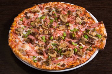 Mantarlı taze İtalyan pizzası ve ahşap masada sosis.