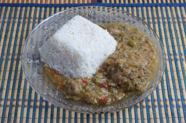 Tipik Senegal tarifi yassa için marine edilmiş baharatlı tavuk, beyaz pirinç ve çeşit çeşit turşu.