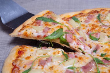 Italian pizza with ham, mozzarella and fresh arugula