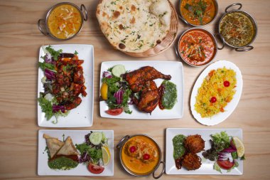 Set of Indian food dishes, with pilau rice, vegetable samosas, red curry