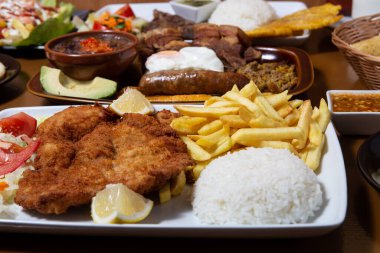 Plate of chicken schnitzel with potato, rice and salad.