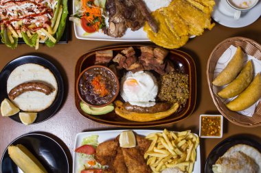 set of assorted dishes of typical Colombian food inside beautiful blue and green plates
