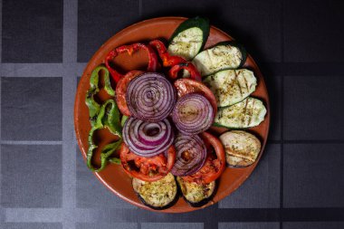 Grilled vegetables with rosemary and thyme on the red plate