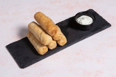 Tequenos adında, peynirle dolu kızarmış mısırdan yapılmış Latin Amerika mezeleri.