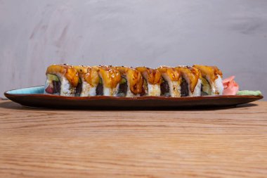 Uramaki suşi rulo somon füme, avokado, krem peynir, chukka ve tobico ile beyaz tabakta. Sushi menüsü. Geleneksel Japon yemekleri.