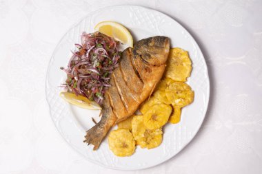 Baked fish called Dorada with banana fries