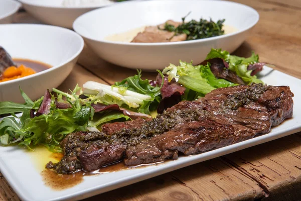 Grilled beef steak with green salad and fried