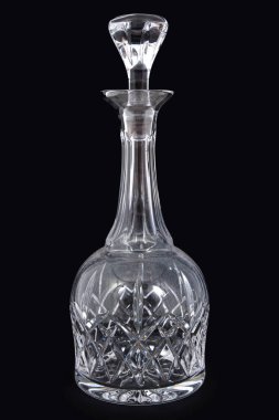 Antique crystal pitcher with glass on black background