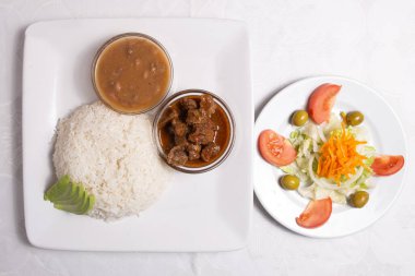 Combo dominicano with rice, meat and fresh salad.