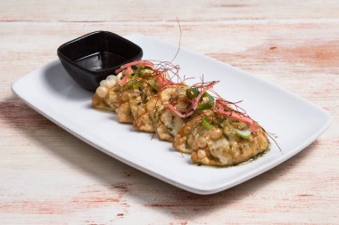 Japanese Cuisine - Pork (or Seafood) Dumplings (gyoza). Garnished on Salad Leaf with Pepper and Fresh Parsley