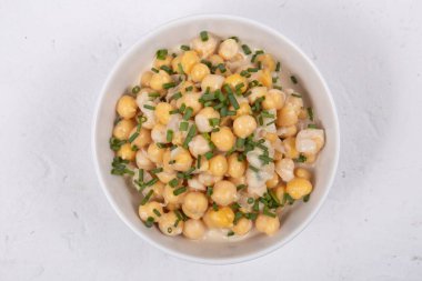 Chickpea salad on a white bowl, selective focus