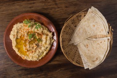 Hummus or houmous, appetizer made of mashed chickpeas, tahini, lemon, garlic, olive oil, parsley and paprika