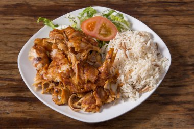 Patates kızartması ve salatalı bir tabak kebap.