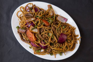 Tallarine tuzlu ya da erişte Peru usulü soğan ve et parçaları.