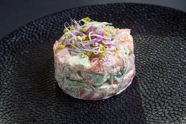 Tartar with salmon and avocado on a black plate