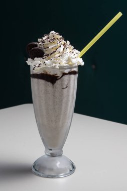 Krem şantili tatlı çikolata kokteyli ve uzun bardakta servis edilen çörekler..