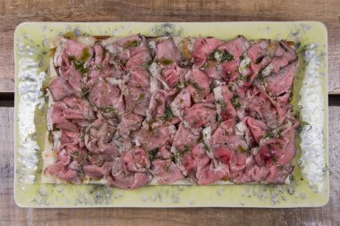 Ahşap arka planda Rosbeef soslu İtalyan pizzası.