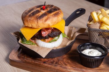 Kızarmış patatesli hamburger ve ketçap.