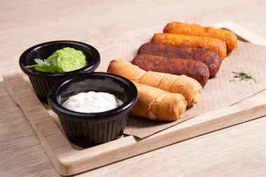 Tequenos adında, peynirle dolu kızarmış mısırdan yapılmış Latin Amerika mezeleri.