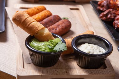 Tequenos adında, peynirle dolu kızarmış mısırdan yapılmış Latin Amerika mezeleri.