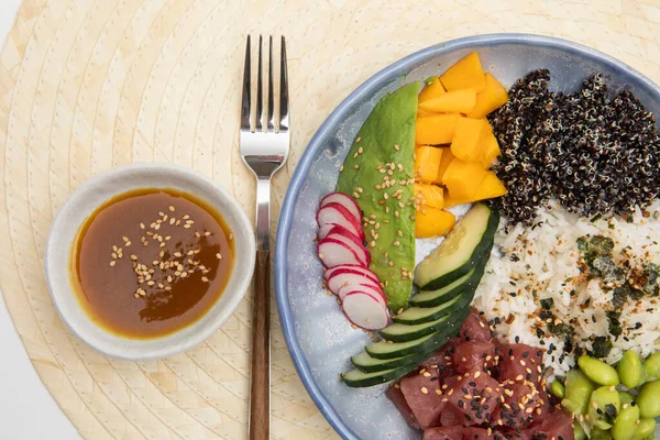 Organic food: tuna poke bowl with rice, fresh cucumbers, red cabbage and avocado