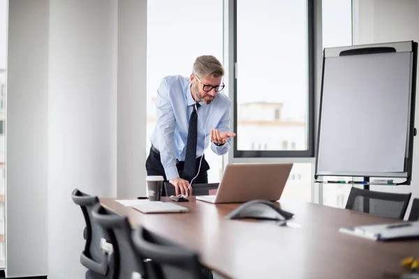 彼の同僚とビデオ通話をしているハンサムなビジネスマン オフィスの机に立っている間に男性プロのシャツとネクタイ — ストック写真