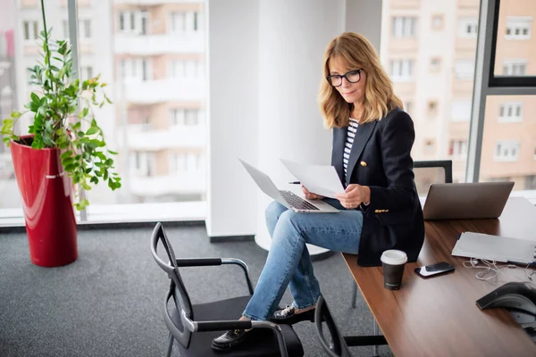 一个漂亮的女商人坐在一个现代化的办公室里 使用笔记本电脑 从事新项目的专业女性 — 图库照片