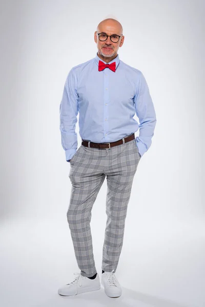 stock image Full length of confident man standing with arms crossed at isolated white background. Smiling caucasian male wearing bow tie and checked trousers. Copy space. 