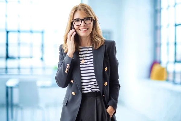 Dojrzała Kobieta Pomocą Smartfona Pewna Siebie Bizneswoman Dzwoniąca Stojąc Biurze — Zdjęcie stockowe